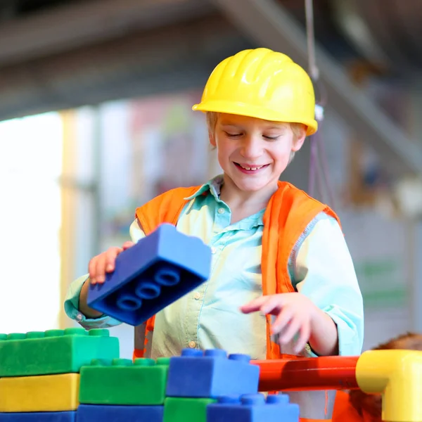 Escuela niño jugando con grandes ladrillos de construcción — Foto de Stock