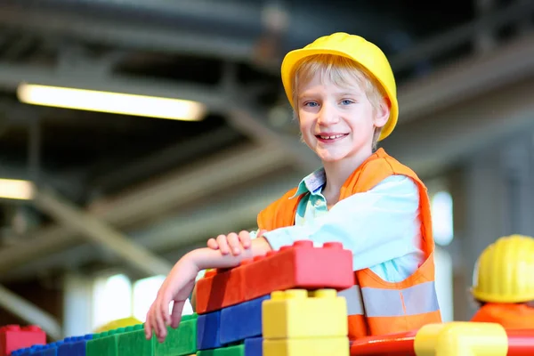 Escuela niño jugando con grandes ladrillos de construcción — Foto de Stock