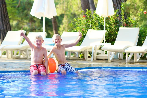 Dos chicos disfrutando de vacaciones de verano en la piscina —  Fotos de Stock