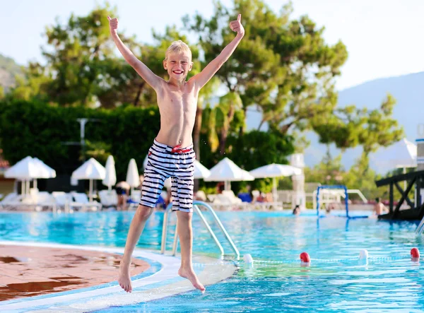 Felice ragazzo che salta in piscina — Foto Stock