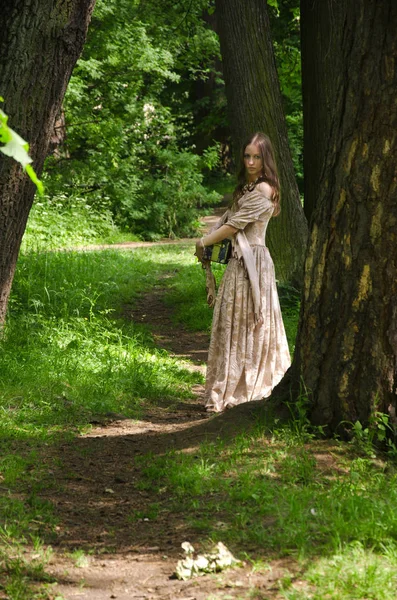 Vrouw in vintage jurk lopen via het steegje van het oude Park — Stockfoto