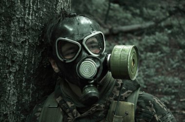 bir gaz maskesi ıslak bir ormandaki asker