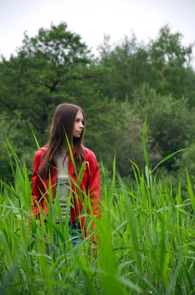 穿红夹克的女人在田野里行走 — 图库照片