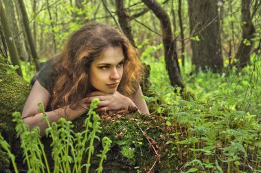 Kız ormanda yosunlu güdük üzerinde dinlenme