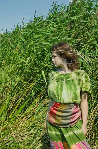 杖の背景に緑のドレスの女の子 — ストック写真