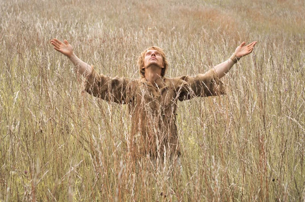 young man in a field peasant costume