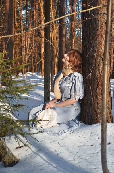 Девушка Синем Платье Сидит Снегу Лесу — стоковое фото