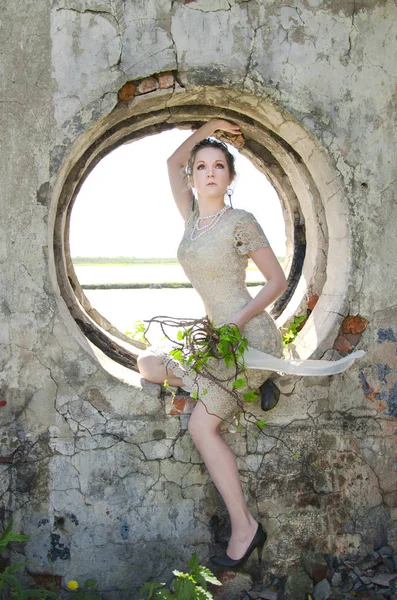 Frau Kurzem Spitzenkleid Sitzt Einer Runden Fensteröffnung Einer Alten Mauer — Stockfoto