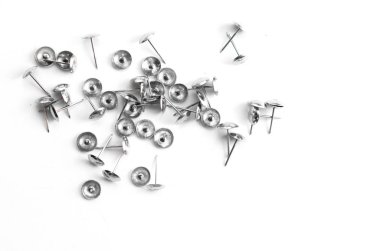 Küçük çivi beyaz bir yüzeye rastgele dağılmış