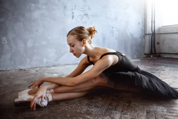 Jeune ballerine en costume de danse noir pose dans un studio loft — Photo