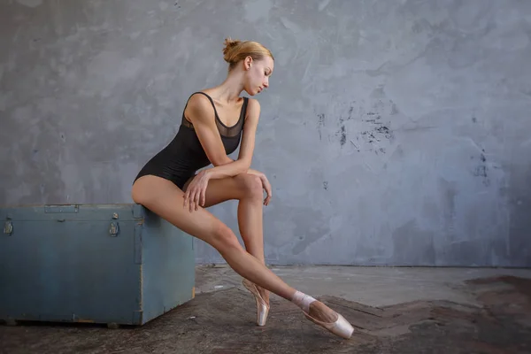 Jeune ballerine en costume de danse noir pose dans un studio loft — Photo