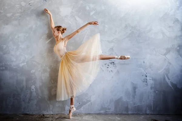 Joven bailarina en un traje de baile de color dorado está posando en un estudio loft — Foto de Stock