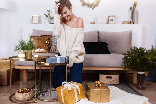 Genç kadın hediyeleri Noel ve yeni yıl için hazırlanıyor. Fotoğraf bir tatil iç yapılır