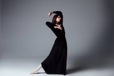 Slim ballerina in a black long dress clipart