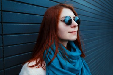 Hipster redhaired kız şık güneş gözlüğü siyah duvar sokak önünde poz