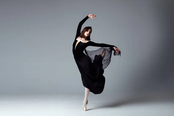 Slim ballerina in a black long dress — Stock Photo, Image