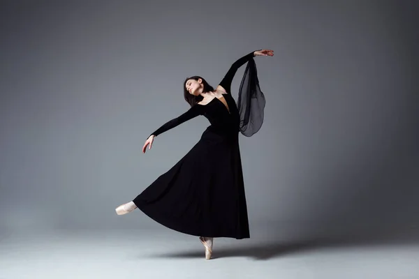 Bailarina delgada en un vestido largo negro — Foto de Stock