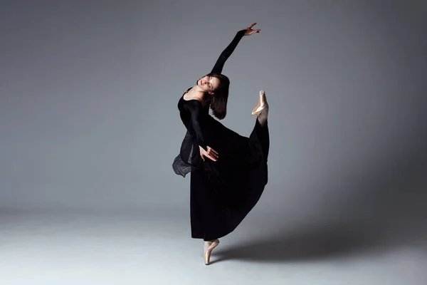 Slim ballerina in a black long dress — Stock Photo, Image