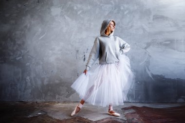 Genç ve ince balet büyük camları olan şık bir stüdyoda poz