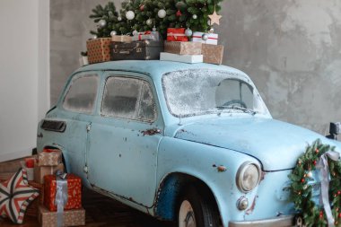 Giftboxes ve xmas ağacı taşıyan mavi retro araba