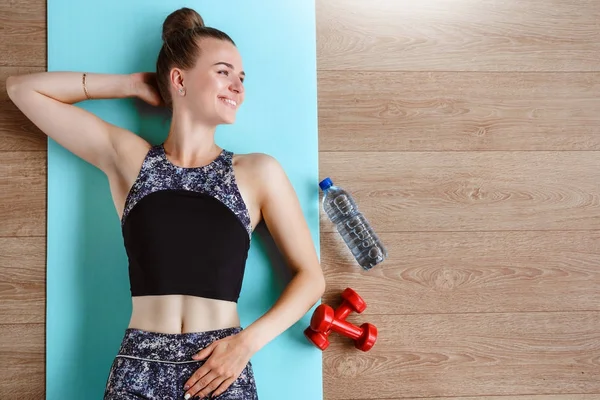 Modelo de fitness delgado está haciendo ejercicio en el suelo en una esterilla de yoga verde — Foto de Stock