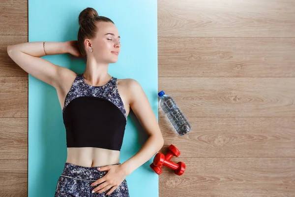 Modelo de fitness delgado está haciendo ejercicio en el suelo en una esterilla de yoga verde — Foto de Stock