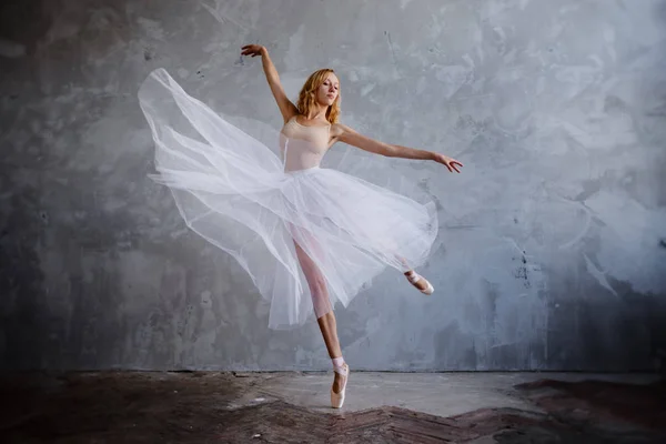 Jeune et mince danseuse de ballet pose dans un studio élégant avec de grandes fenêtres — Photo