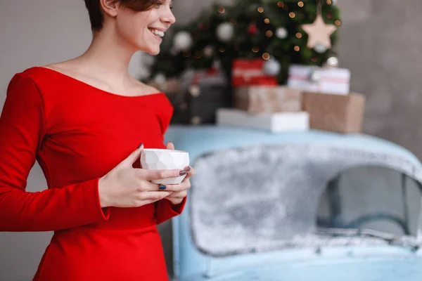 Rapariga em um vestido vermelho está posando em um interior decored Natal — Fotografia de Stock