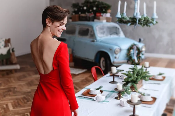 Rapariga em um vestido vermelho está posando em um interior decored Natal — Fotografia de Stock
