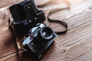 Retro fotoğraf makinesi şık ahşap arka plan üzerinde beyaz Not Defteri ile