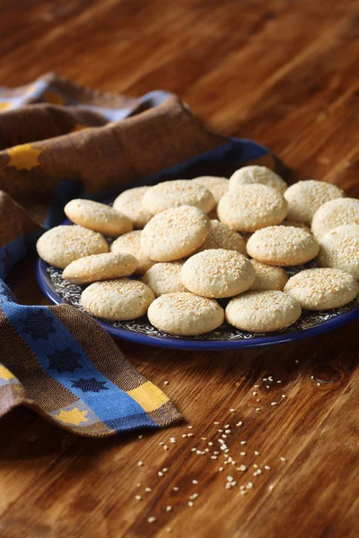 Galletas de sésamo en plato azul oscuro — Foto de Stock