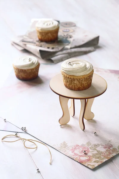Babeczki waniliowe na mały stolik drewniany — Zdjęcie stockowe