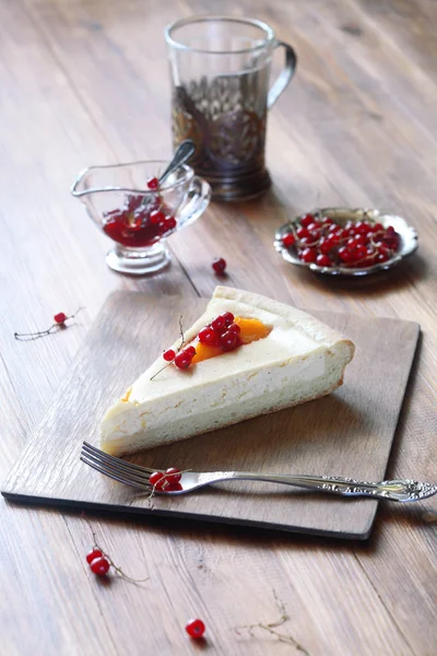 Stück Käsekuchen mit Pfirsichen und roten Johannisbeeren — Stockfoto