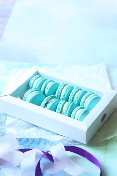 Blaue Macarons mit Frischkäse und Blaubeerfüllung, auf hellblauem Hintergrund. — Stockfoto