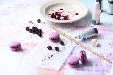 Çikolata Siyah frenk üzümü doldurma ile ışık arka plan üzerinde mor Macarons.