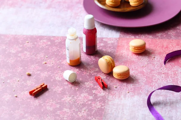 Hafif mor çiçek arka planda turuncu Macarons.