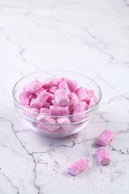 Cam şeffaf bir kasede, açık mermer bir masada pembe şekerlemeler..