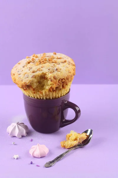 Muffin Cake with Walnuts, powdered with icing sugar, on purple background.