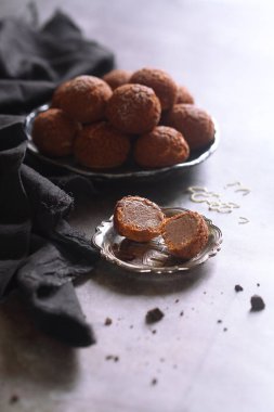 Craquelin ile çikolatalı kekler, krema şekeri ile pudralanmış, gri arka planda, bir tabakta.