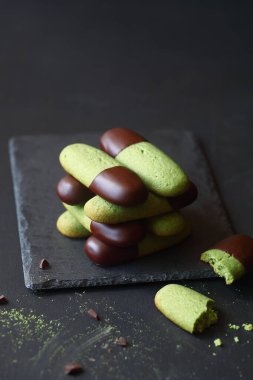 Çikolata soslu kiraz çayı tereyağlı kurabiyeler, koyu bir arka planda..