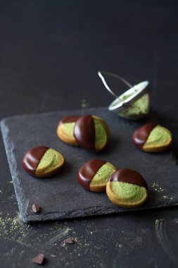 Çikolata soslu kiraz çayı tereyağlı kurabiyeler, koyu bir arka planda..