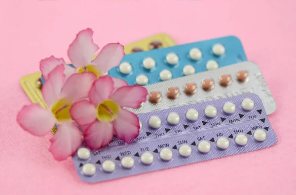 Orale anticonceptiva op roze achtergrond in vrouwen gezondheid concept. — Stockfoto