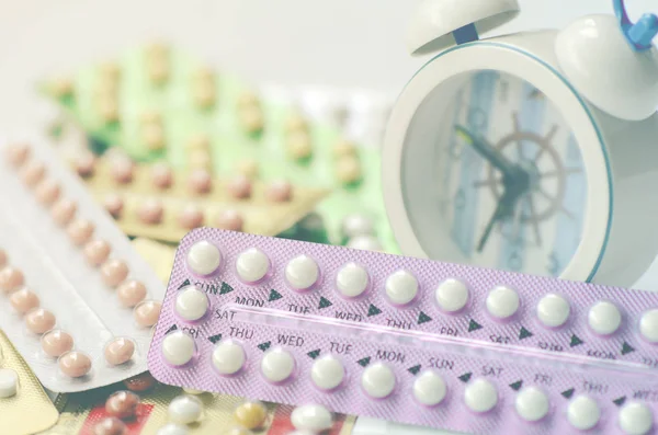 Mondelinge contraceptieve pillen met wekker achtergrond. — Stockfoto