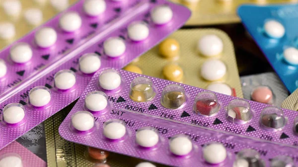 Oral contraceptive pill on pharmacy counter with colorful pills — Stock Photo, Image