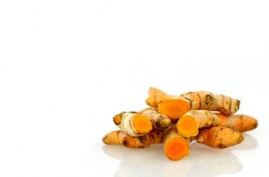 Beyaz arkaplanda zerdeçal kökleri.