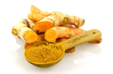 Çay kaşığı zerdeçal kökü tozu ile beyaz arka plan üzerinde zerdeçal kökü.