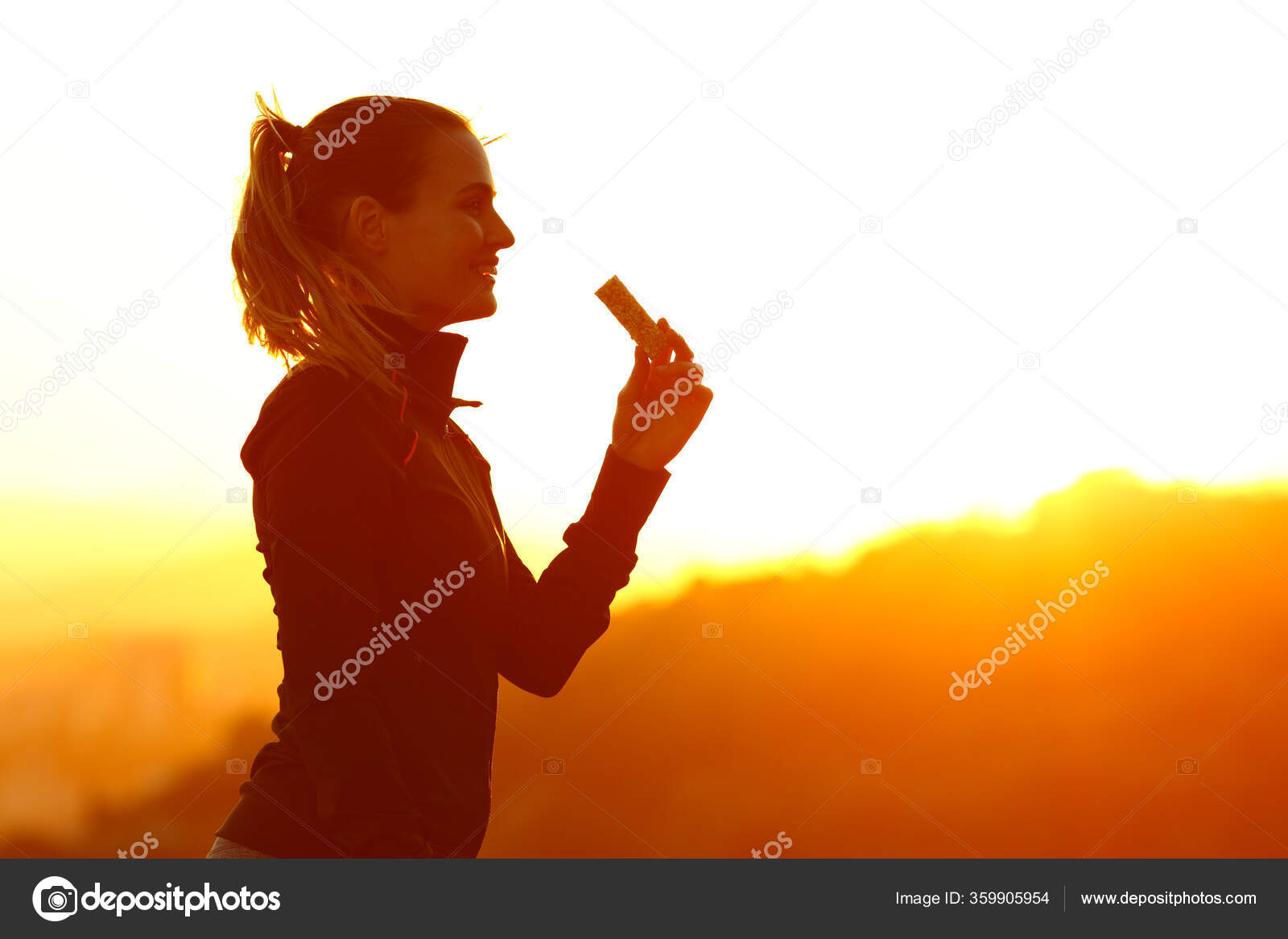 silueta-mujer-corredora-comiendo-barra-energ-a-despu-s-correr-atardecer