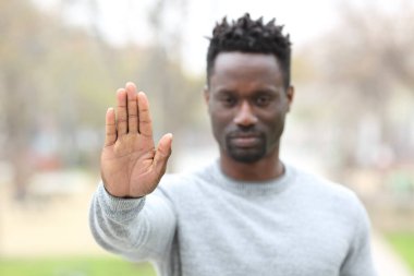 Kızgın bir zencinin ön manzara portresi. El hareketlerini parkta göstermeyi bırak.