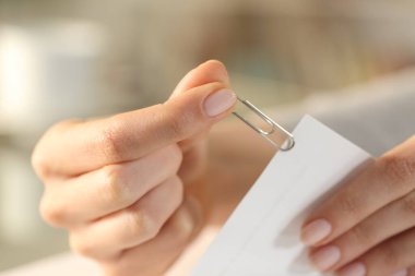 Kadın ellerine yakın doküman kağıtlarının üzerine gümüş bir ataç koyun.