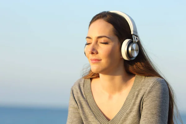 Kulaklıklı Kadın Gün Batımında Plajda Müzik Dinliyor — Stok fotoğraf